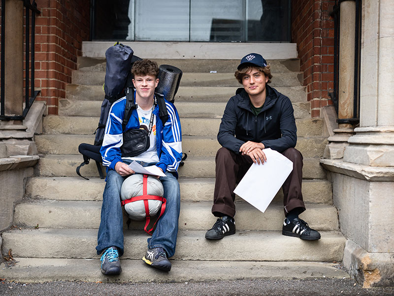 Two male pupils receive their results at school